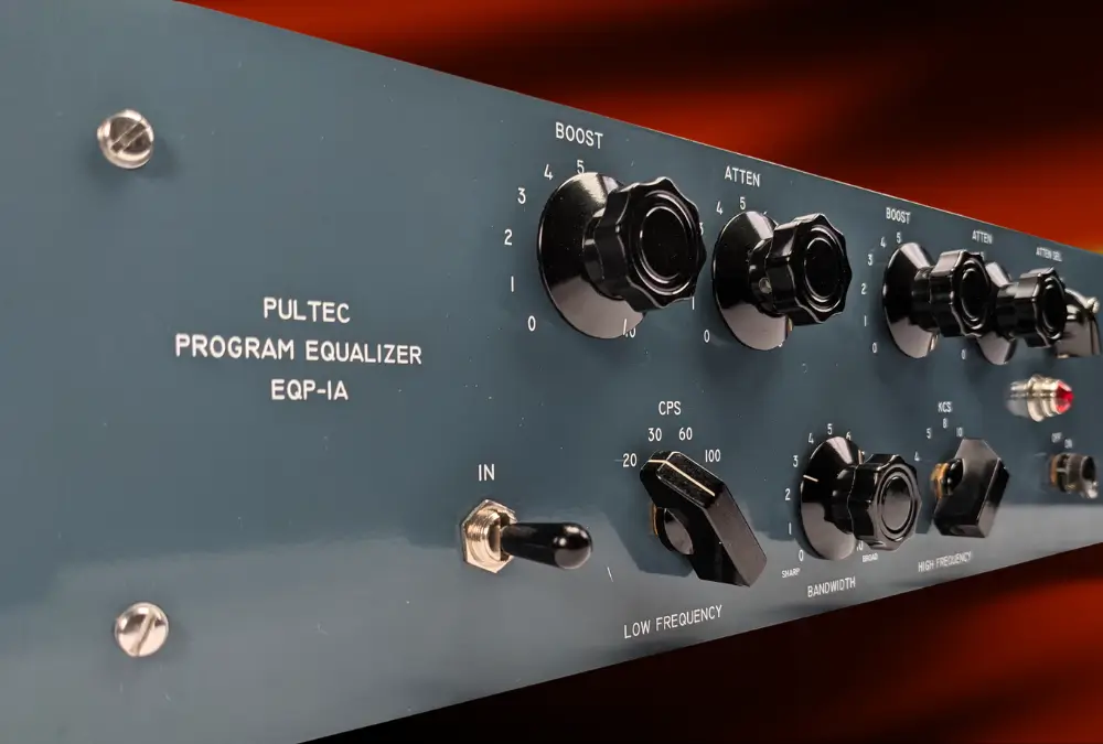 Angled close-up of a Pultec EQP-1A front panel showing the Boost, Atten and Low Frequency controls