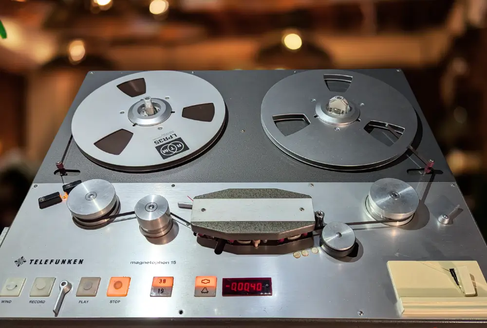 The Access Analog Telefunken M15 magnetophon 15 tape machine, front panel showing the WIND, RECORD, PLAY and STOP transport buttons, the 38/19 cm-per-second speed selector, and RTM LPR35 tape loaded on both reels.
