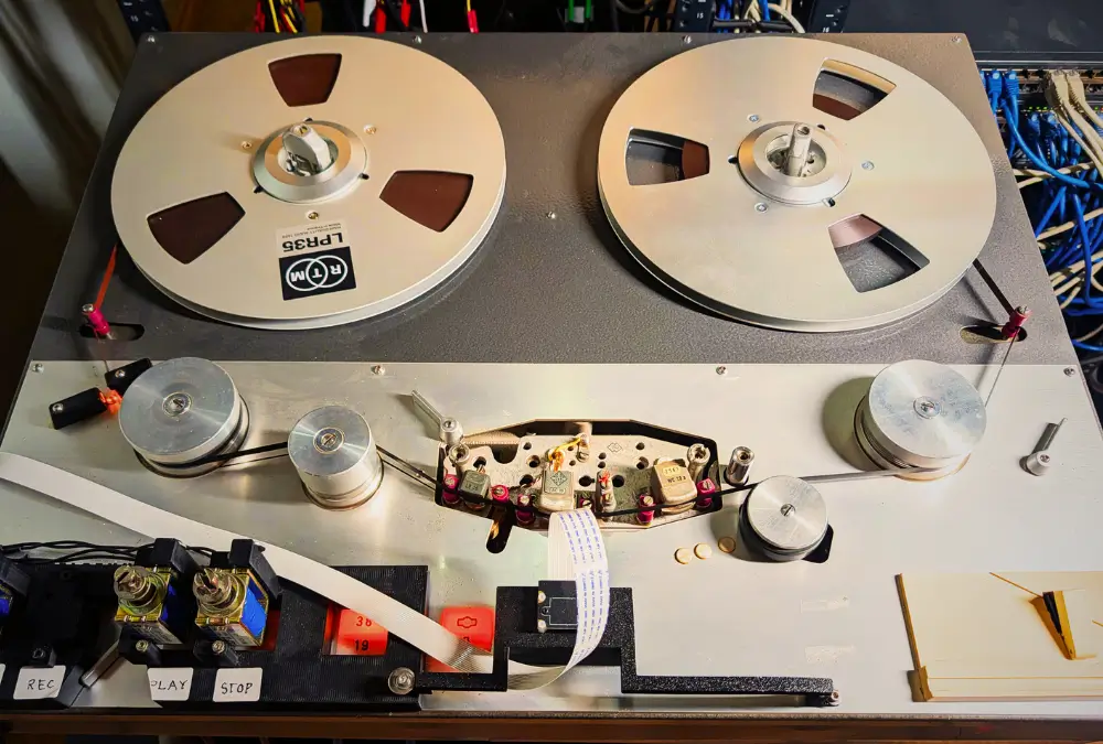 Top-down view of the Access Analog Telefunken M15 with robotic actuators mounted over the deck's REC, PLAY and STOP buttons, showing the tape path and exposed head block.